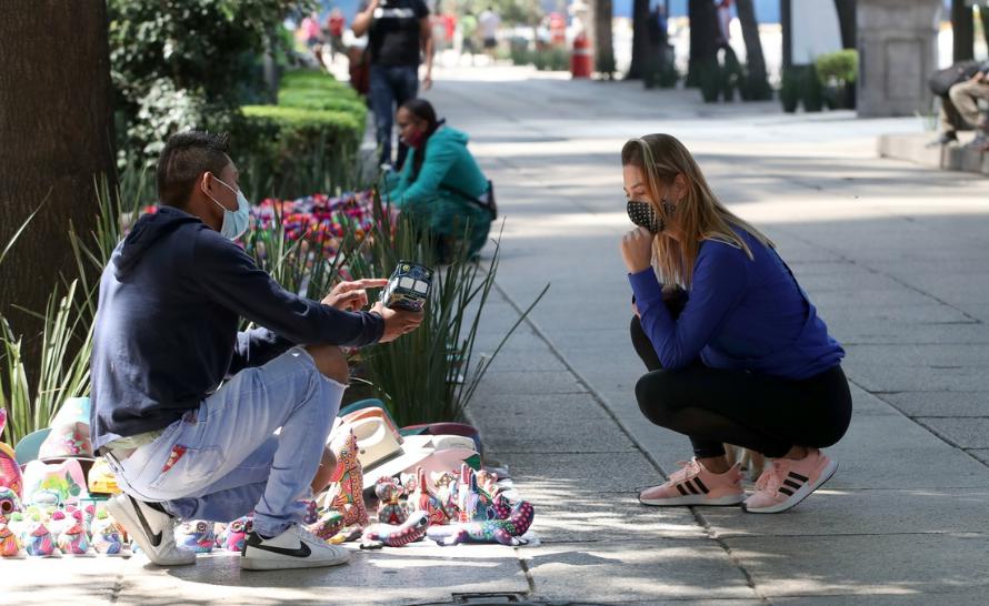 Una turista negocia con un comerciante sobre Avenida Paseo de la Reforma, el 3 de febrero de 2021. Foto José Antonio López