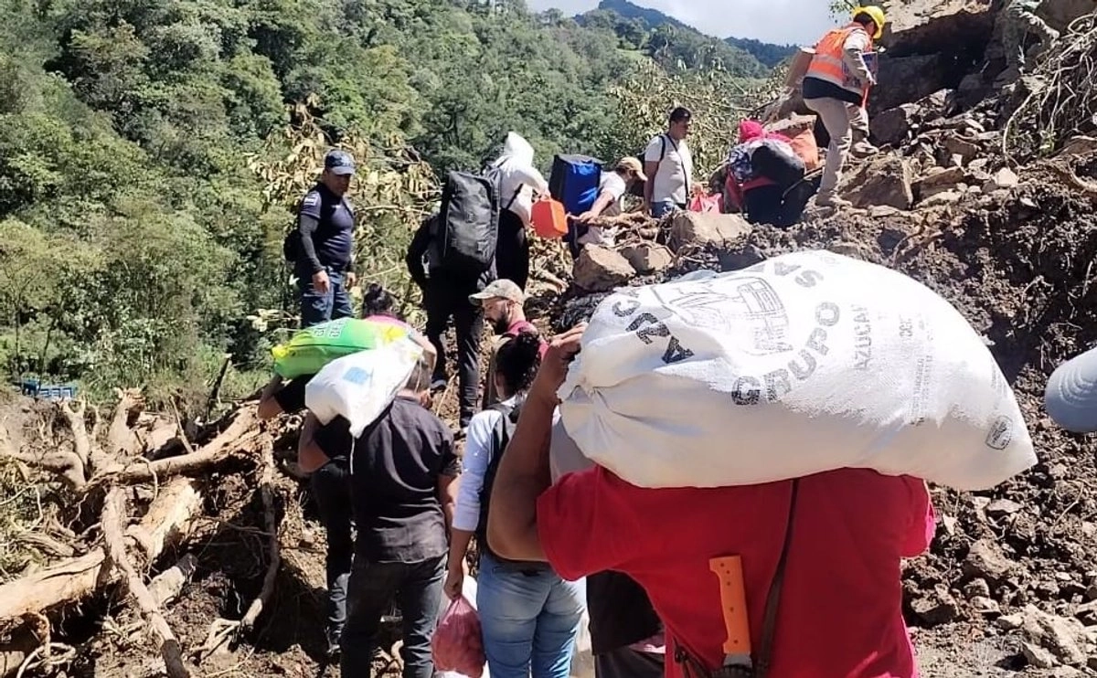 Entre lodo y veredas, vecinos cruzan cerro para llevar víveres a Huehuetla
