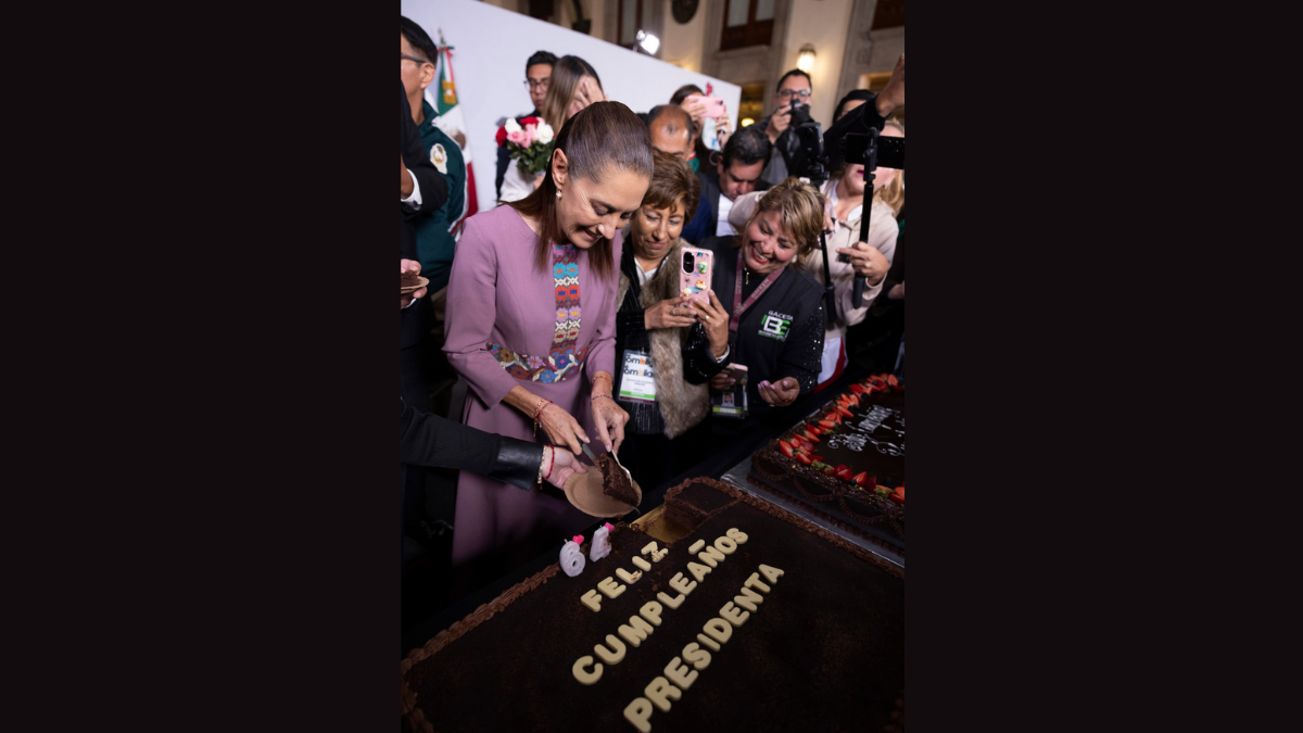La presidenta Claudia Sheinbaum parte un pastel durante la celebración de su cumpleaños número 64 en Palacio Nacional.
